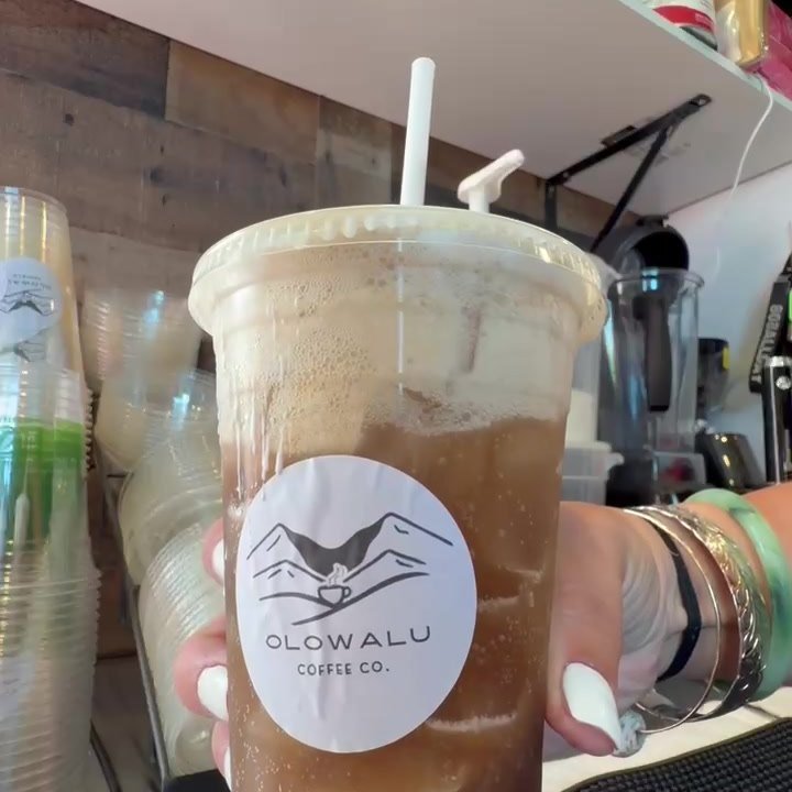 A pink dirty soda in a clear Olowalu Coffee Co cup.