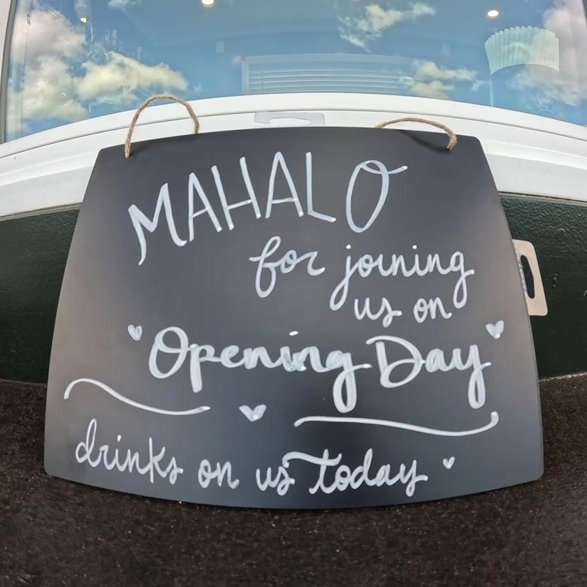A chalkboard at the trailer reading Mahalo for joining us on opening day.