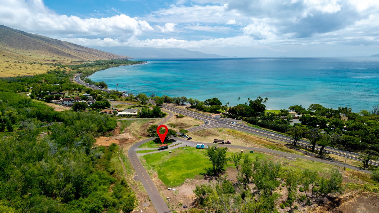 An aerial view of the Olowalu coastline with a map pin on the Olowalu Coffee Co trailer, just off the Honoapiilani Highway beside the water.